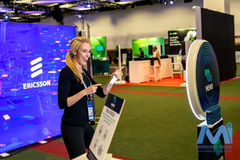 guests posing in front of branded photo booth at expo