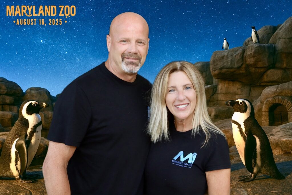 owners tim & kelly posing in front of the digital photo booth and digital background